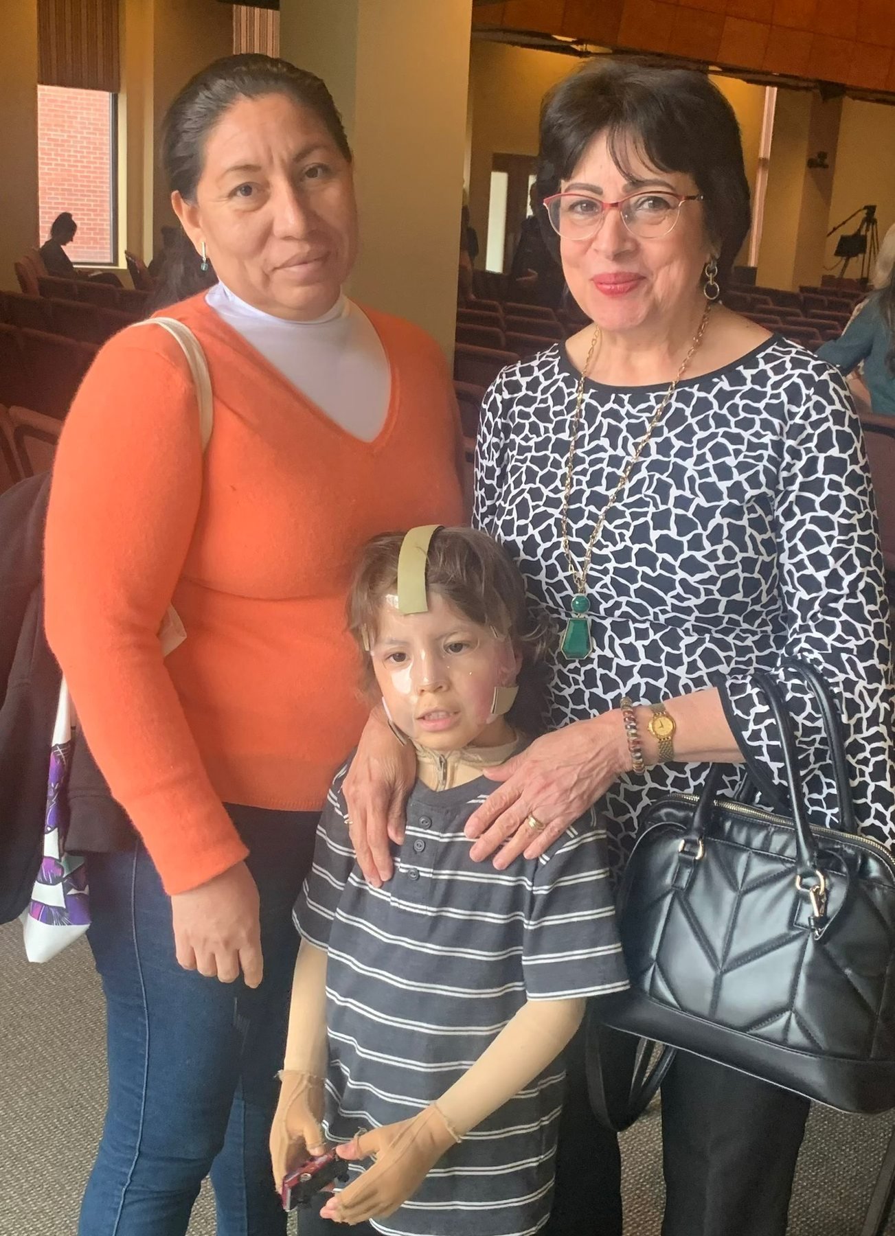 A mother and a volunteer accompanying a young child during recovery in Boston