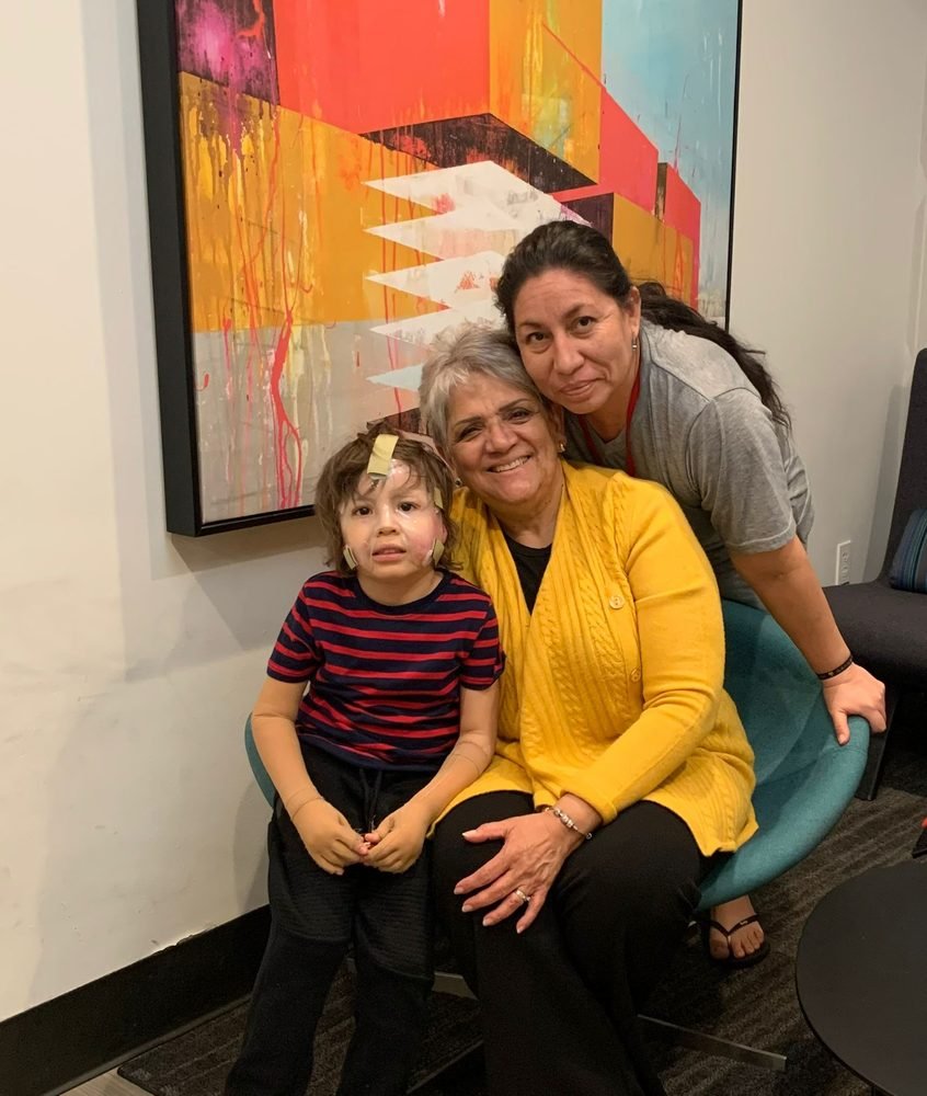 A boy with his mother and volunteers sitting together