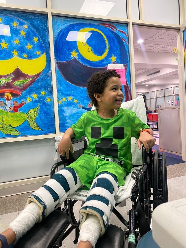 A smiling boy in a wheelchair in the hospital playroom
